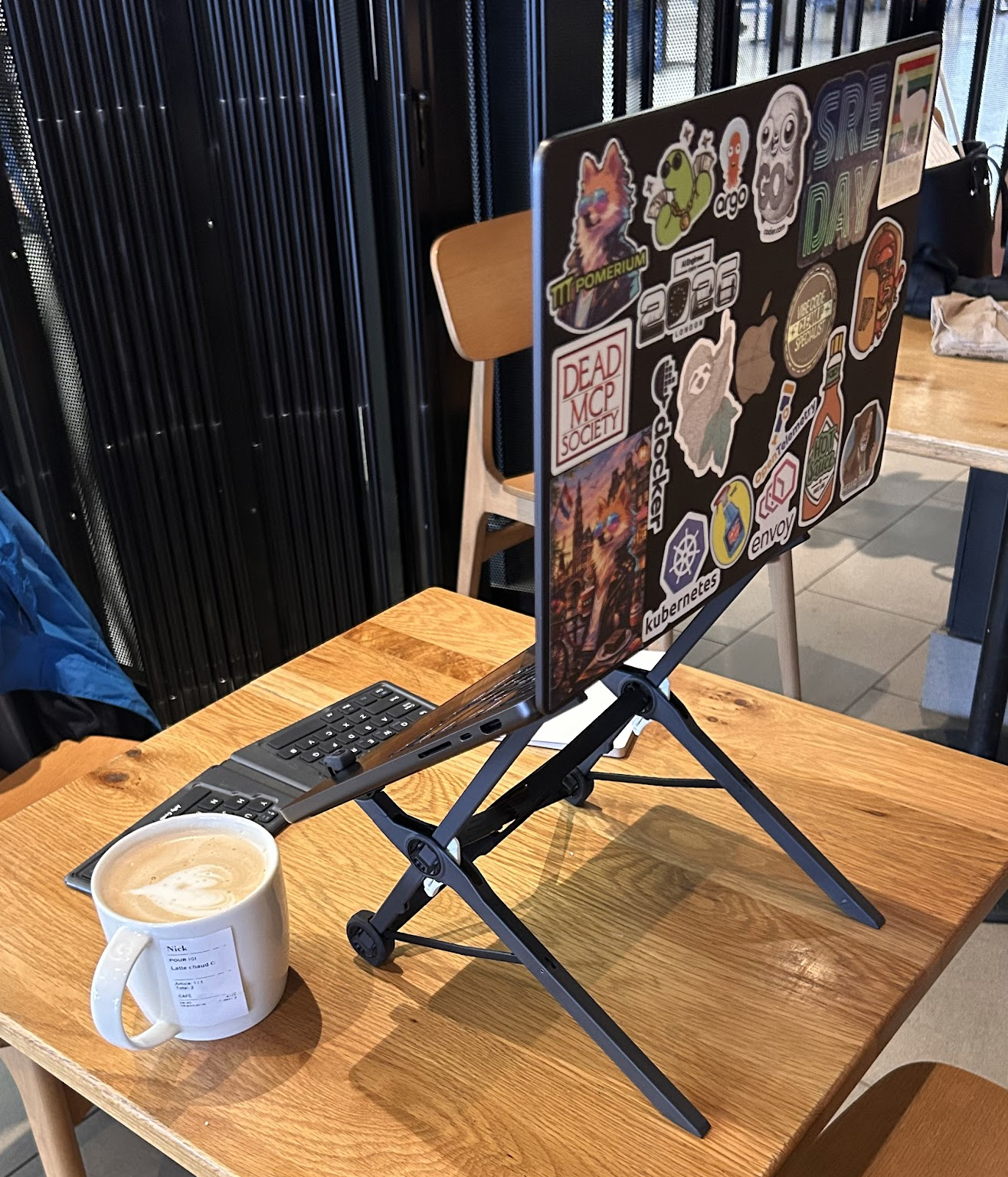 My laptop sitting on my laptop stand in a coffee shop